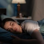 woman laying in bed at night awake, worrying.