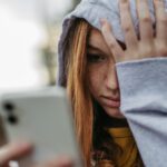 stressed out teen on phone - cyberbullying and mental health in teenagers