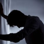 Miramont - Why Do BPD and NPD Get Confused. A shaddowy man braces against a wall with his head down in clear distress.